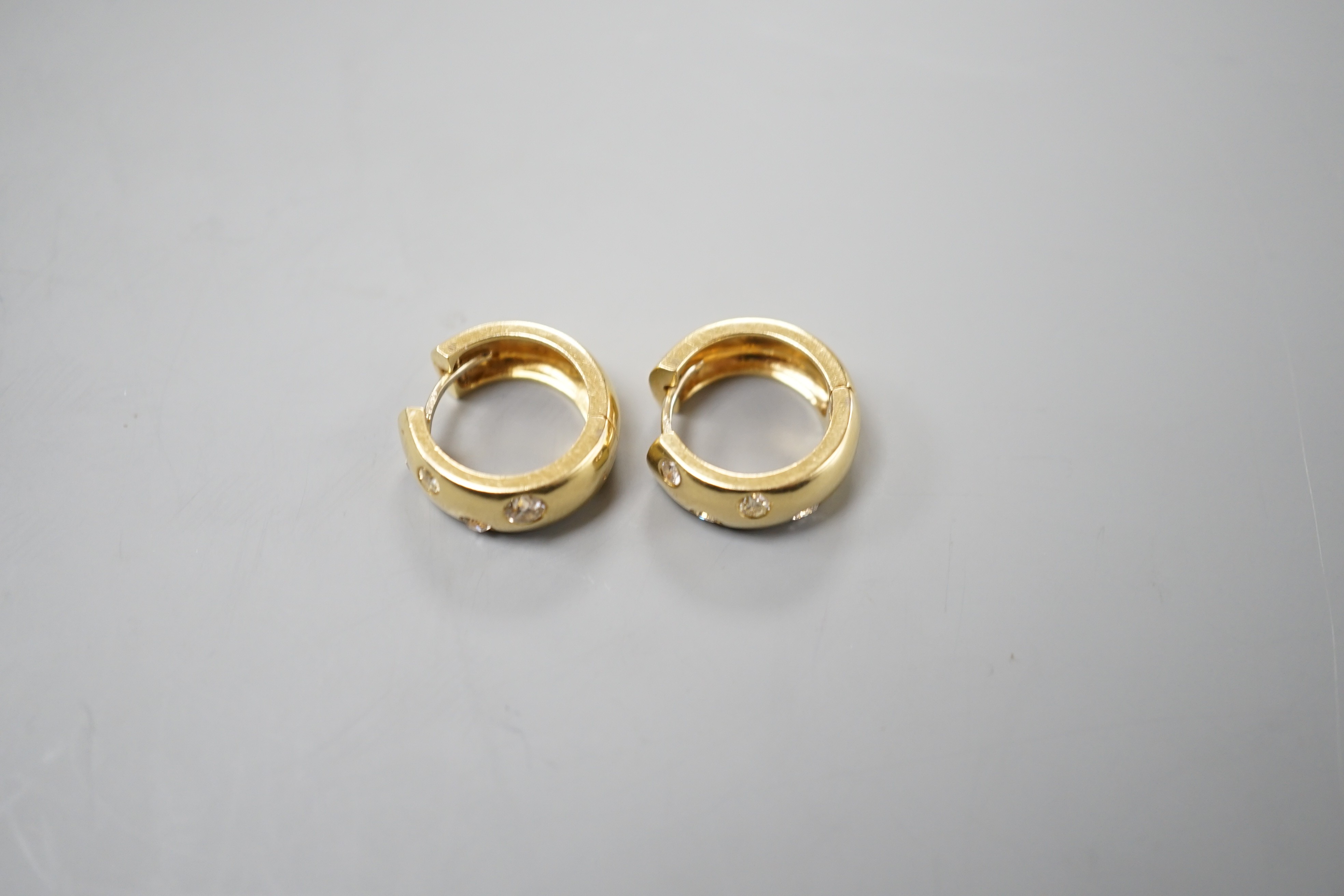 A modern pair of 750 yellow metal and four stone gypsy set diamond hoop earrings, 16mm, gross weight 11 grams.